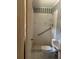Small bathroom with a white toilet, sink, shower, grab bar, and striped wallpaper at 4595 Sahara Sw Dr, Atlanta, GA 30331