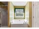 Bathroom features a standalone bathtub and window with decorative curtain, creating a luxurious space at 80 Jacob Trl, Rockmart, GA 30153