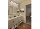 Bathroom featuring double vanity with white cabinets, mirrors, towels and wood-look flooring at 1081 Hardin Street Sw St, Conyers, GA 30012
