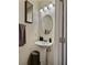 Stylish powder room with pedestal sink, oval mirror, three-light vanity, and decorative bottles at 1081 Hardin Street Sw St, Conyers, GA 30012