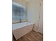 Modern bathroom features a sleek, freestanding bathtub with wood look flooring at 1081 Hardin Street Sw St, Conyers, GA 30012