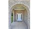 Close-up of the brick-arched front porch with white front door and sidelights at 1081 Hardin Street Sw St, Conyers, GA 30012