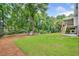 Expansive backyard featuring green grass, mature trees, a wooden fence, and a storage shed at 1625 Bill Murdock Rd, Marietta, GA 30062
