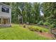 Spacious backyard featuring a lush lawn, mature trees, wood privacy fence, and storage shed at 1625 Bill Murdock Rd, Marietta, GA 30062