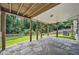Covered patio with stone flooring, wooden pillars, and a view of the spacious, green backyard at 1625 Bill Murdock Rd, Marietta, GA 30062