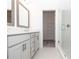 Modern bathroom featuring double sinks, sleek cabinetry, walk-in shower with glass door and a view into the walk-in closet at 352 Olmstead Way # 28, Alpharetta, GA 30022
