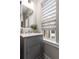 Elegant bathroom featuring a gray vanity, herringbone tile, and ample natural light from the window at 506 Broadview Ne Pl, Atlanta, GA 30324