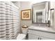 Modern bathroom featuring a shower with gray-and-white striped curtain and updated vanity at 506 Broadview Ne Pl, Atlanta, GA 30324