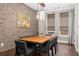 Elegant dining room featuring a large table, modern chandelier, and brick accent wall at 506 Broadview Ne Pl, Atlanta, GA 30324