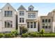 Charming, modern, three-story white brick home with black-trimmed windows, black metal fence, and verdant landscaping at 506 Broadview Ne Pl, Atlanta, GA 30324