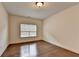 Empty bedroom features a window, wood floors, white walls, and a neutral color scheme at 5485 Sandstone Ct, Cumming, GA 30040