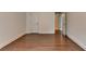 The empty bedroom offers wood floors, white walls, two doors; one leading to a closet and the other to the hallway at 5485 Sandstone Ct, Cumming, GA 30040