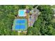 Aerial view showcasing the community pool, tennis courts, playground, and surrounding lush greenery at 5485 Sandstone Ct, Cumming, GA 30040