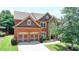 Beautiful two-story home featuring brick and stone accents, well-manicured lawn, and a two-car garage at 5485 Sandstone Ct, Cumming, GA 30040