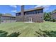 Exterior view showing spacious backyard, large lawn and two story home with dual windows at 5485 Sandstone Ct, Cumming, GA 30040