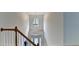Sunlit foyer showcasing a chandelier and staircase with wooden railings at 5485 Sandstone Ct, Cumming, GA 30040