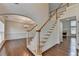 Bright foyer with hardwood floors, staircase, and an archway leading to the dining room at 5485 Sandstone Ct, Cumming, GA 30040