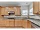Corner of the kitchen featuring stainless steel appliances, light wood cabinets and granite countertops at 5485 Sandstone Ct, Cumming, GA 30040