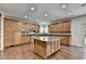 Modern kitchen with granite countertops, wooden cabinets, stainless steel appliances, and hardwood floors at 5485 Sandstone Ct, Cumming, GA 30040