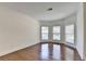 Sunlit living room with hardwood floors, crown molding, and large windows offering neighborhood views at 5485 Sandstone Ct, Cumming, GA 30040