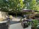 Serene backyard featuring outdoor seating and dining areas, lush greenery, and shade trees for relaxation and entertainment at 127 Spring Way Sq, Canton, GA 30114
