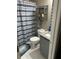 Bathroom featuring granite countertop, white tile floor, and striped shower curtain offers practical features at 127 Spring Way Sq, Canton, GA 30114