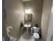 Half bath features a pedestal sink, toilet, decorative mirror, and neutral color scheme at 127 Spring Way Sq, Canton, GA 30114