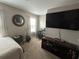 Bedroom with a large TV, desk, round mirror and guitar offers both relaxation and productivity at 127 Spring Way Sq, Canton, GA 30114