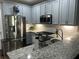 Bright kitchen with stainless steel appliances, granite countertops, subway tile backsplash, and light blue cabinets at 127 Spring Way Sq, Canton, GA 30114