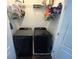 Laundry room with black washer and dryer units and storage shelves, maximizing space for laundry needs at 127 Spring Way Sq, Canton, GA 30114
