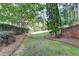 Lush backyard with mature trees and brick accent at 1723 Woodbow Path, Dacula, GA 30019