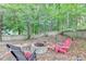 The backyard features a stone fire pit area with seating and a wooded backdrop with a fence at 1723 Woodbow Path, Dacula, GA 30019