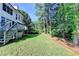 The backyard shows a lush green lawn and wooded area, with the back of the house at 1723 Woodbow Path, Dacula, GA 30019