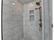 Modern shower featuring bronze shower head, marble surround, and built-in shower niche at 1723 Woodbow Path, Dacula, GA 30019
