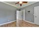 A simply styled bedroom featuring a ceiling fan, hardwood floors and neutral walls at 1723 Woodbow Path, Dacula, GA 30019