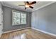 A simply styled bedroom featuring a ceiling fan, hardwood floors and neutral walls at 1723 Woodbow Path, Dacula, GA 30019