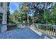 A wood deck with a gray wooden railing overlooks the backyard and beautiful wooded area at 1723 Woodbow Path, Dacula, GA 30019