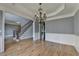 Open dining room area featuring hardwood floors, chandelier and staircase at 1723 Woodbow Path, Dacula, GA 30019