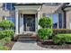 Close-up of a front door with beautiful shrubbery, plants and flowers around the entry at 1723 Woodbow Path, Dacula, GA 30019