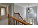 A bright, airy hallway is featured with a decorative chandelier and natural light from the foyer at 1723 Woodbow Path, Dacula, GA 30019