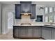 Beautiful kitchen featuring dark blue cabinets, marble countertops, stainless steel appliances, and hardwood flooring at 1723 Woodbow Path, Dacula, GA 30019