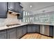 Modern kitchen with dark blue cabinets, stainless steel appliances, marble countertops, and hardwood floors at 1723 Woodbow Path, Dacula, GA 30019