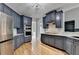 Modern kitchen with dark blue cabinets, stainless steel appliances, marble countertops, and hardwood floors at 1723 Woodbow Path, Dacula, GA 30019