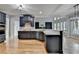 Spacious kitchen featuring dark blue cabinetry, marble countertops, stainless steel appliances, and hardwood flooring at 1723 Woodbow Path, Dacula, GA 30019