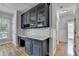 Kitchenette area with dark blue cabinets, marble countertops, cabinets with glass doors, and hardwood floors at 1723 Woodbow Path, Dacula, GA 30019