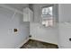 Functional laundry room with overhead shelving and a window, providing natural light and ventilation at 1723 Woodbow Path, Dacula, GA 30019
