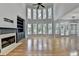 Bright living room boasts hardwood floors, a fireplace, built-in shelving, and large windows at 1723 Woodbow Path, Dacula, GA 30019