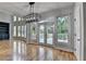 Living room with hardwood floors, chandelier, large windows, and access to outdoor deck at 1723 Woodbow Path, Dacula, GA 30019
