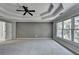 Spacious primary bedroom with tray ceiling, fan, and neutral carpet at 1723 Woodbow Path, Dacula, GA 30019