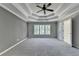 Spacious primary bedroom with tray ceiling, fan, and neutral carpet at 1723 Woodbow Path, Dacula, GA 30019